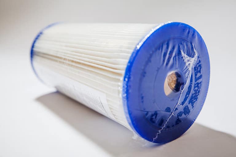 Blue and white cylindrical water filter cartridge.