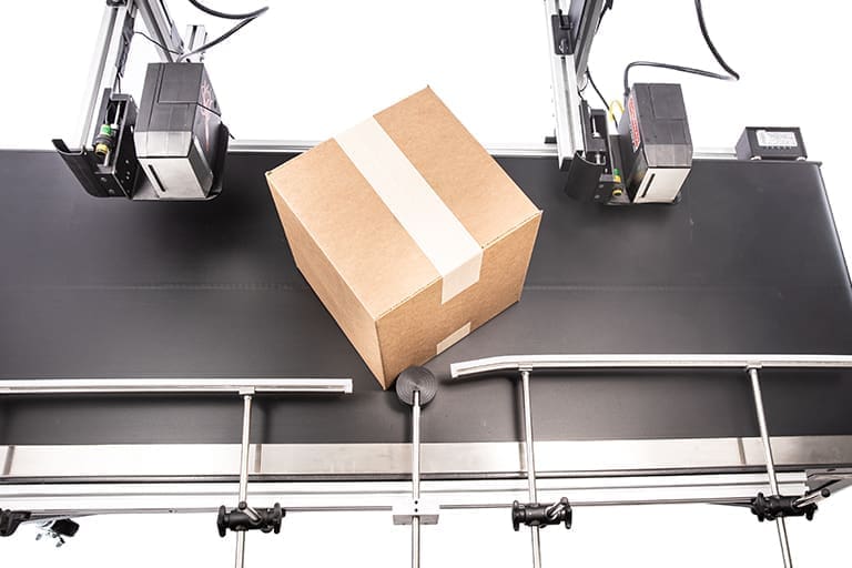A box on a conveyor line with two industrial printers