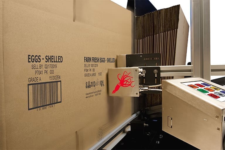 Machine printing label on egg carton box.