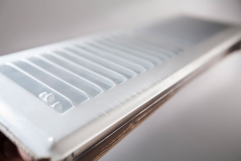 Close-up of a white air vent grille.