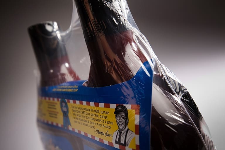 Barbecue sauce bottles wrapped in plastic.
